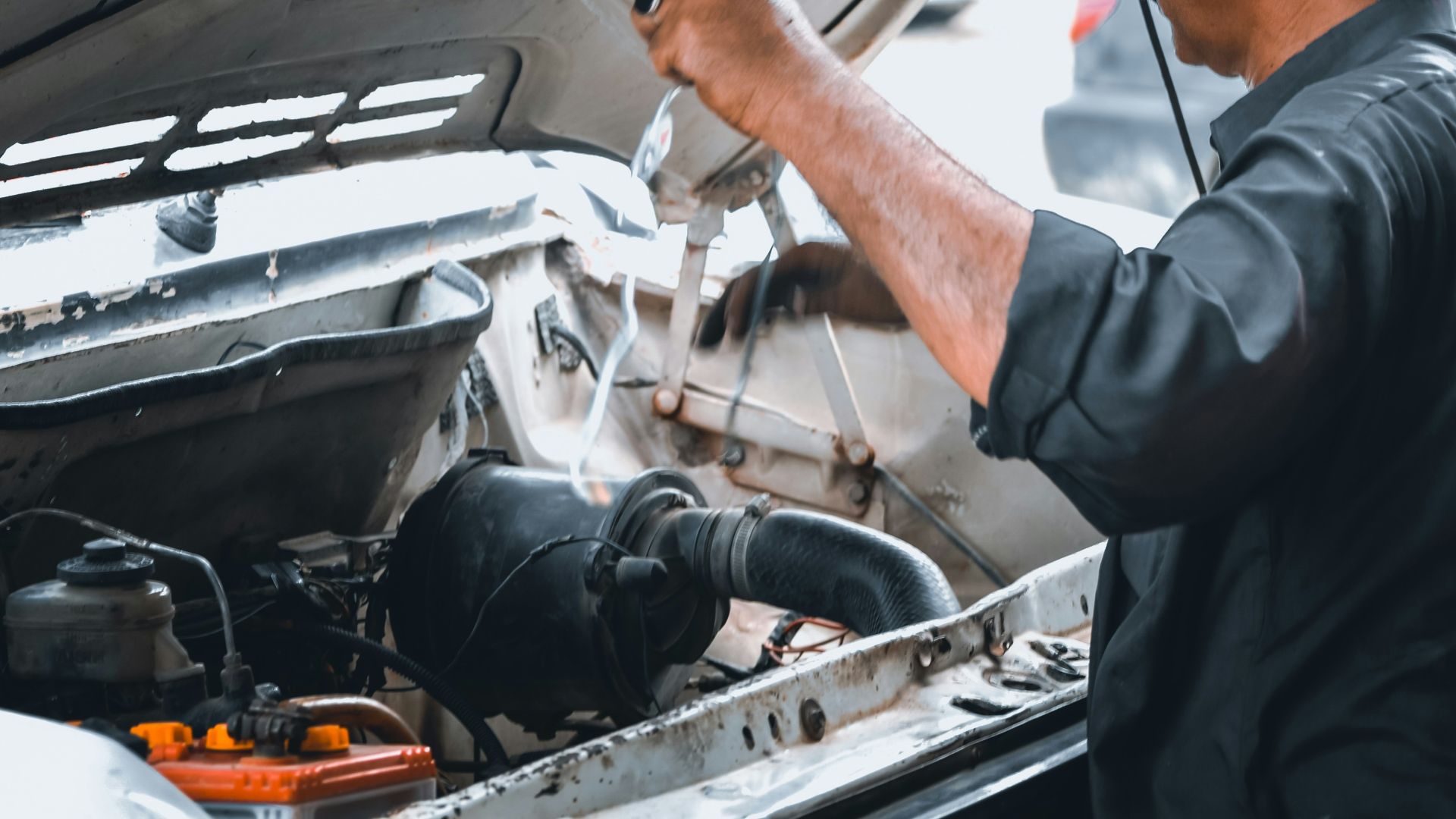 man repairing white vehicle