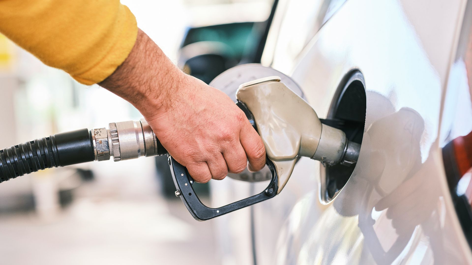 a man pumping gas into his car at a gas station