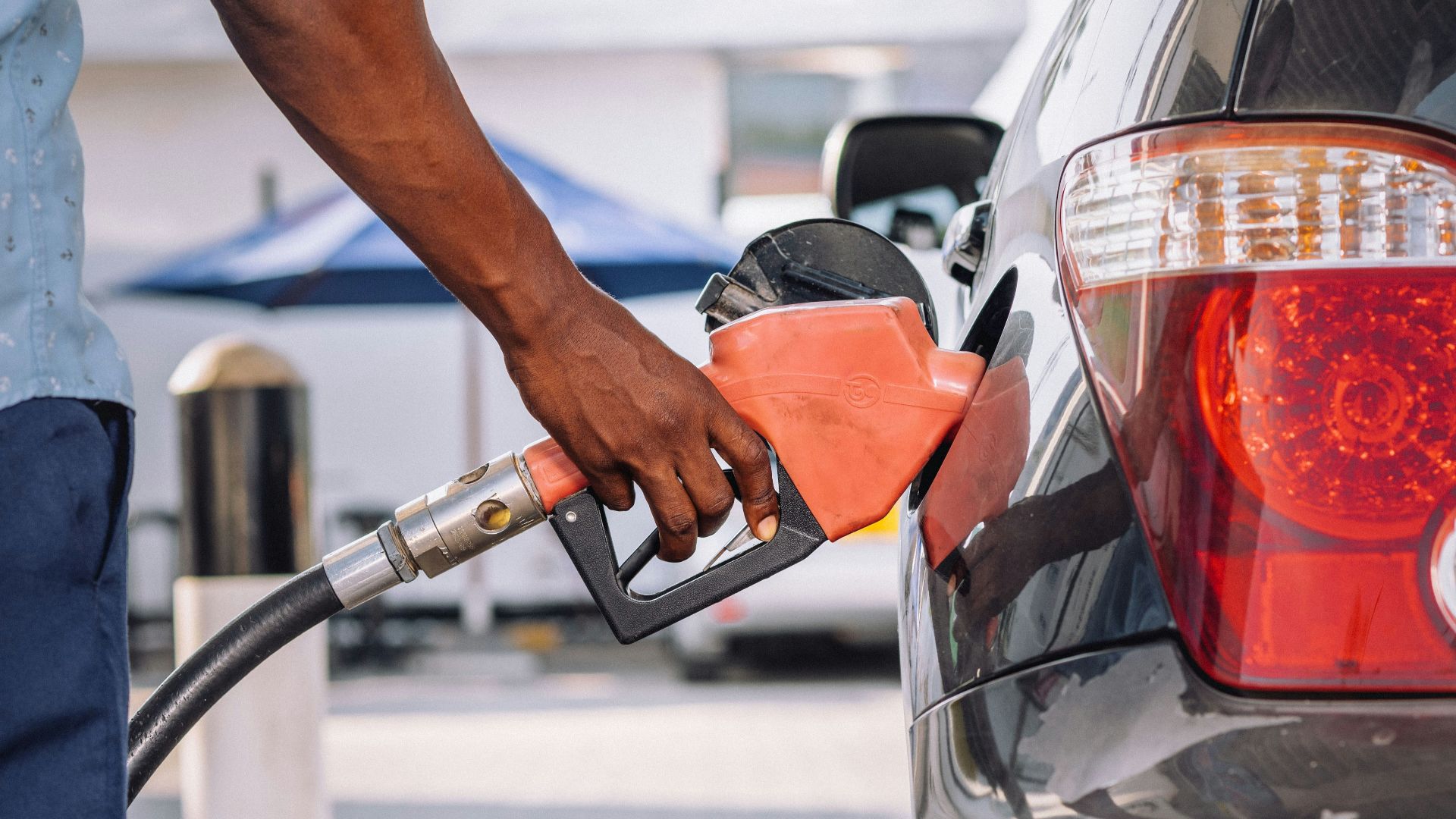 a man pumping gas into his car at a gas station