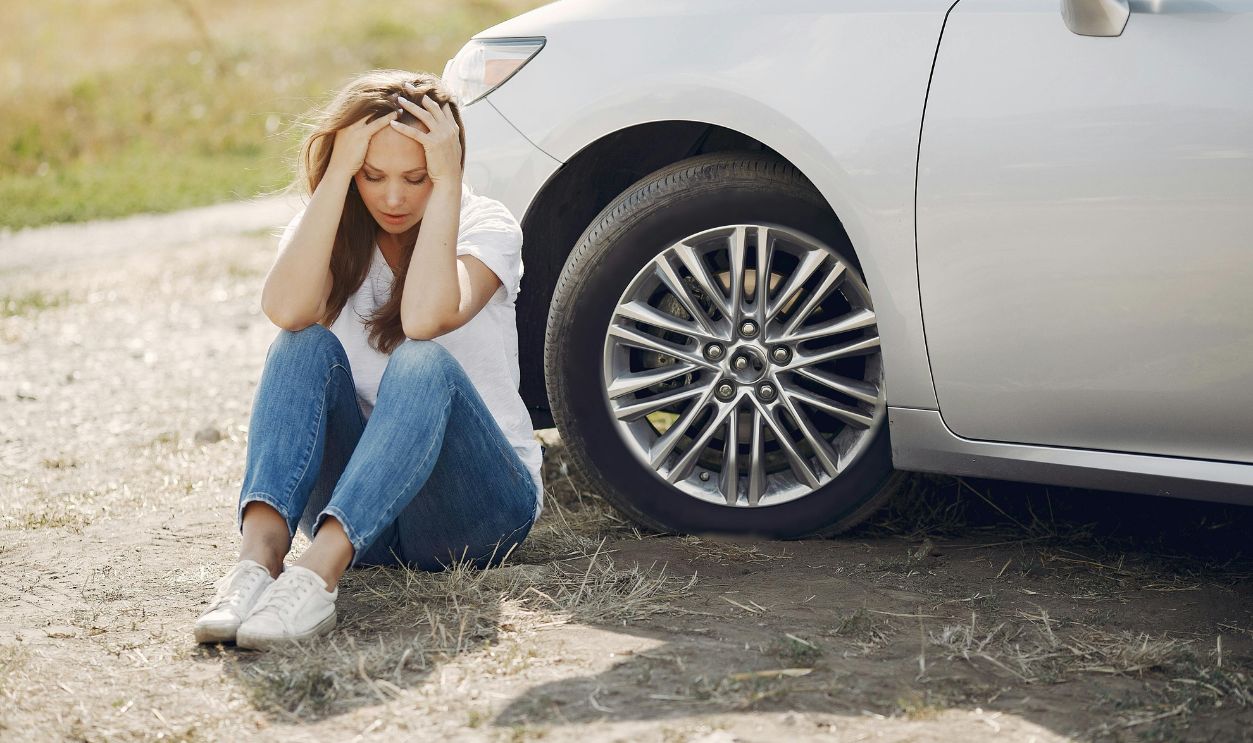 Young woman upset with car trouble, stranded roadside in rural area 