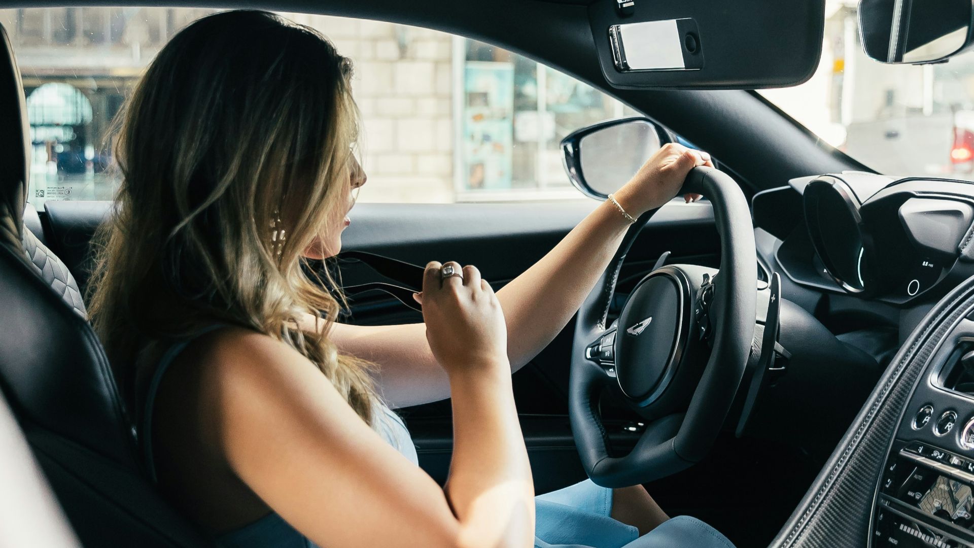 woman wearing white tank top driving vehicle during daytime