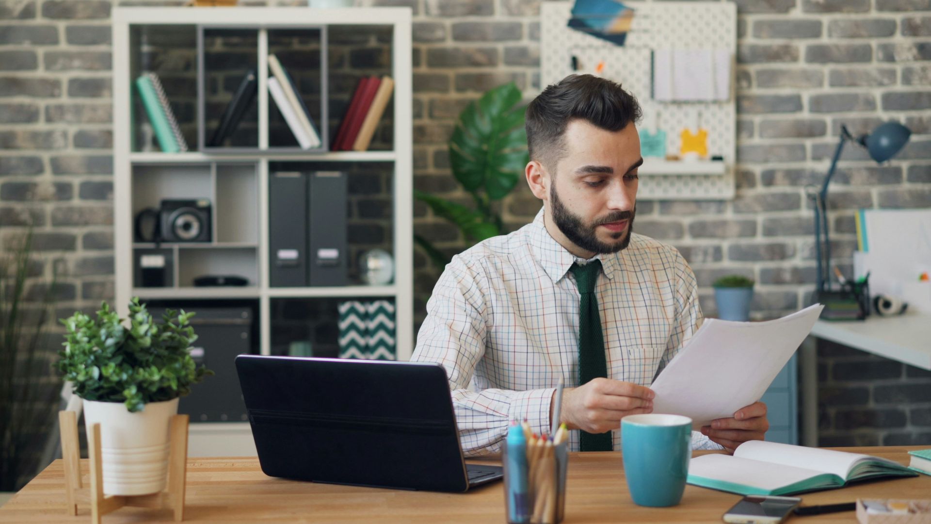 a man sitting at a desk in front of a laptop