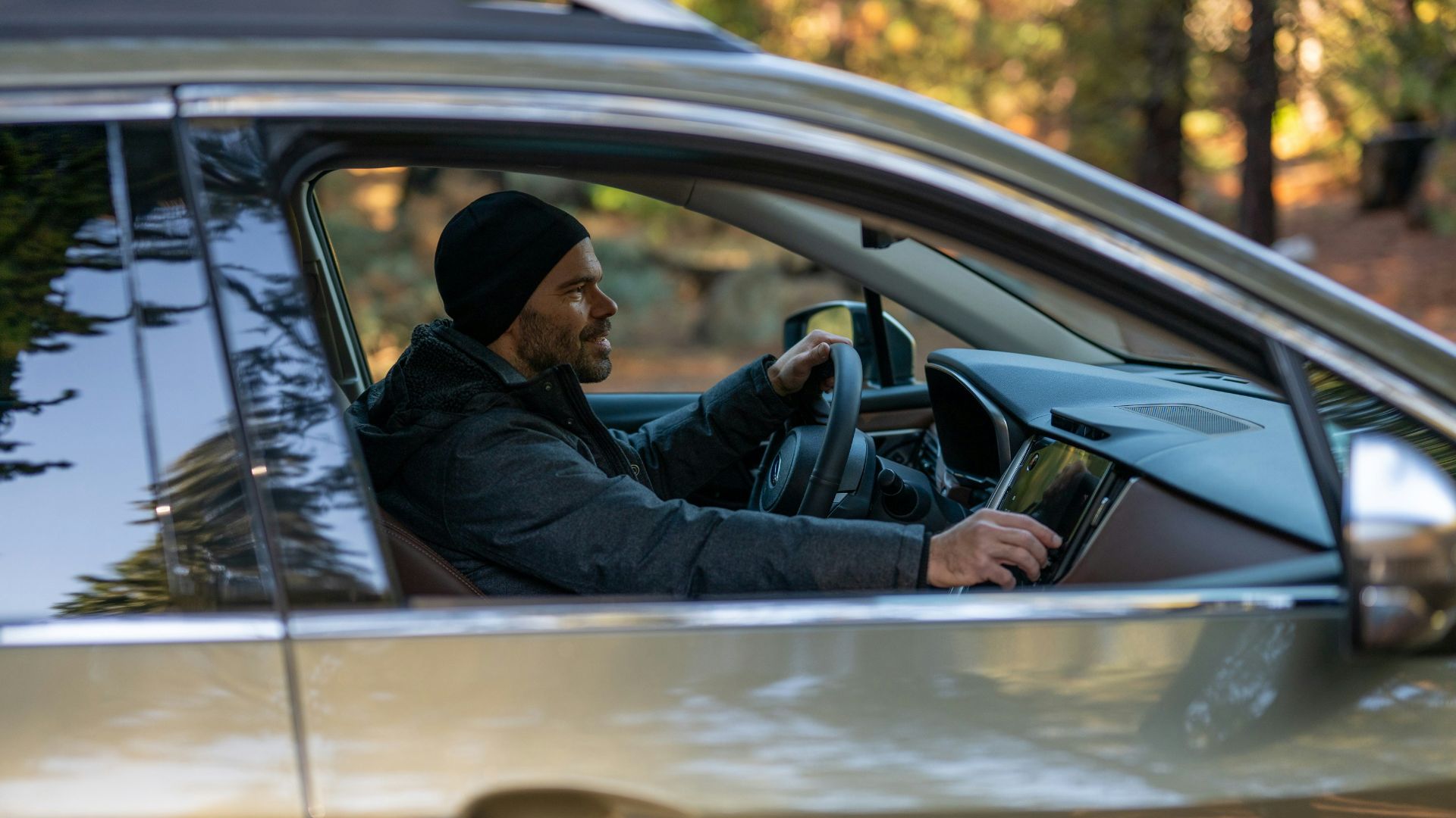 A man driving a car in a wooded area