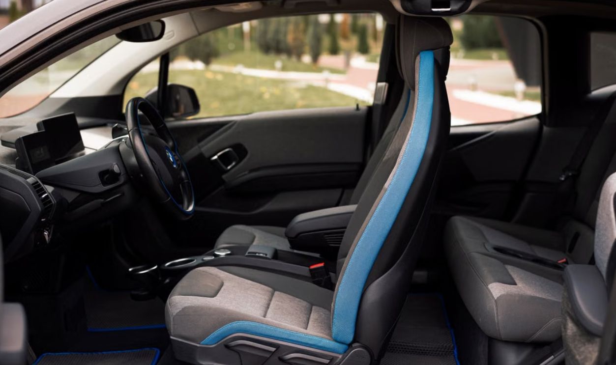 A sleek interior of a modern car showcasing the front and rear seats and steering wheel details