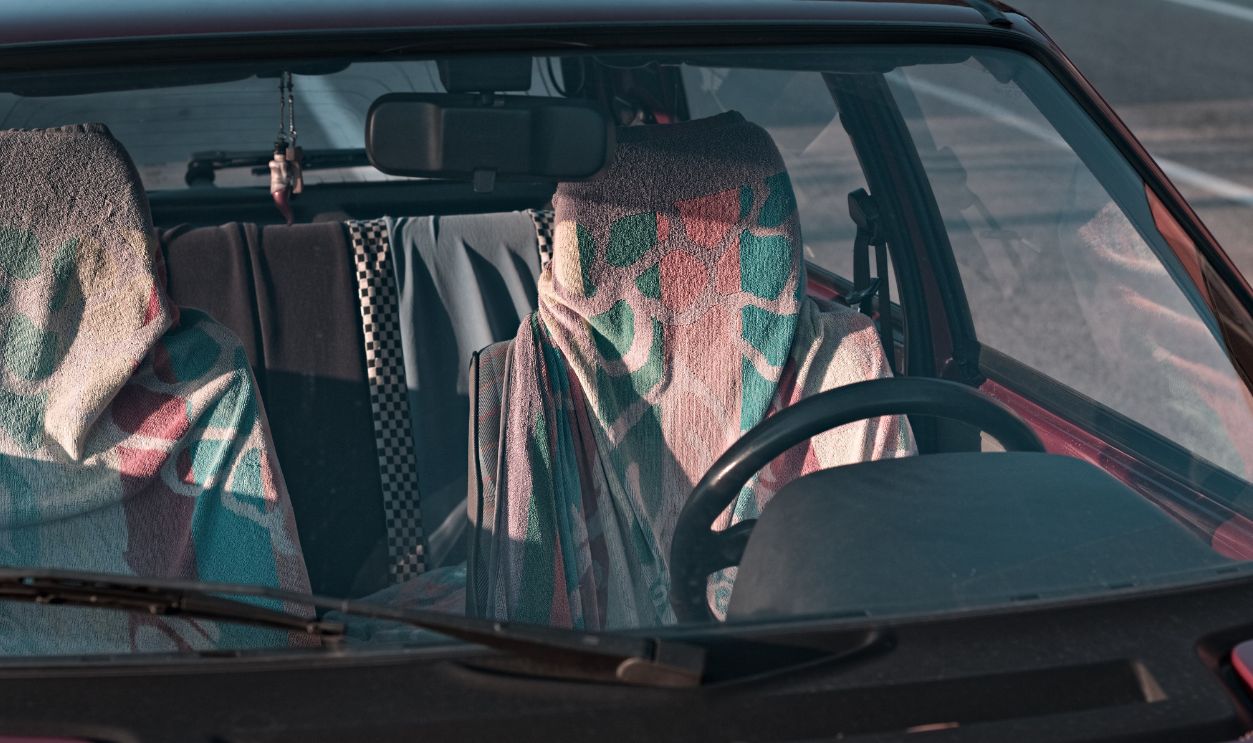 The seats of a red vintage car covered in colorful towels (Marche, Italy, Europe)