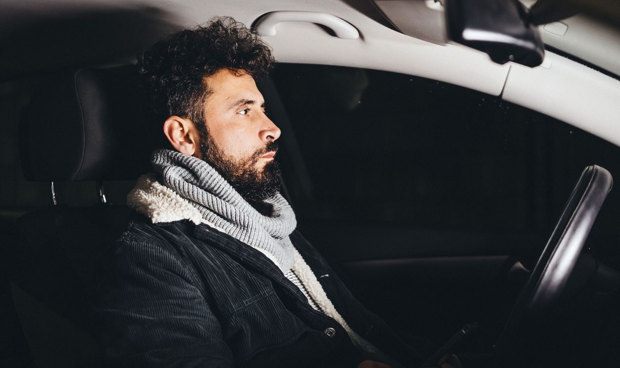 Adult man driving a car at night
