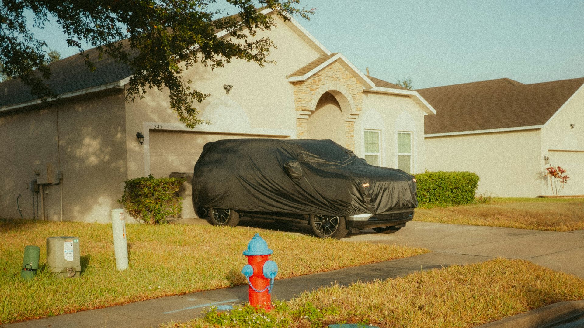 A car parked on the side of a road in front of a house