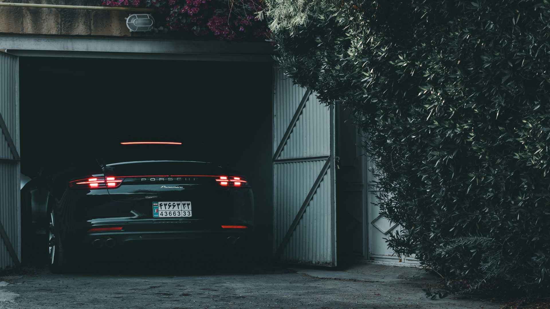 black car parked beside black metal gate
