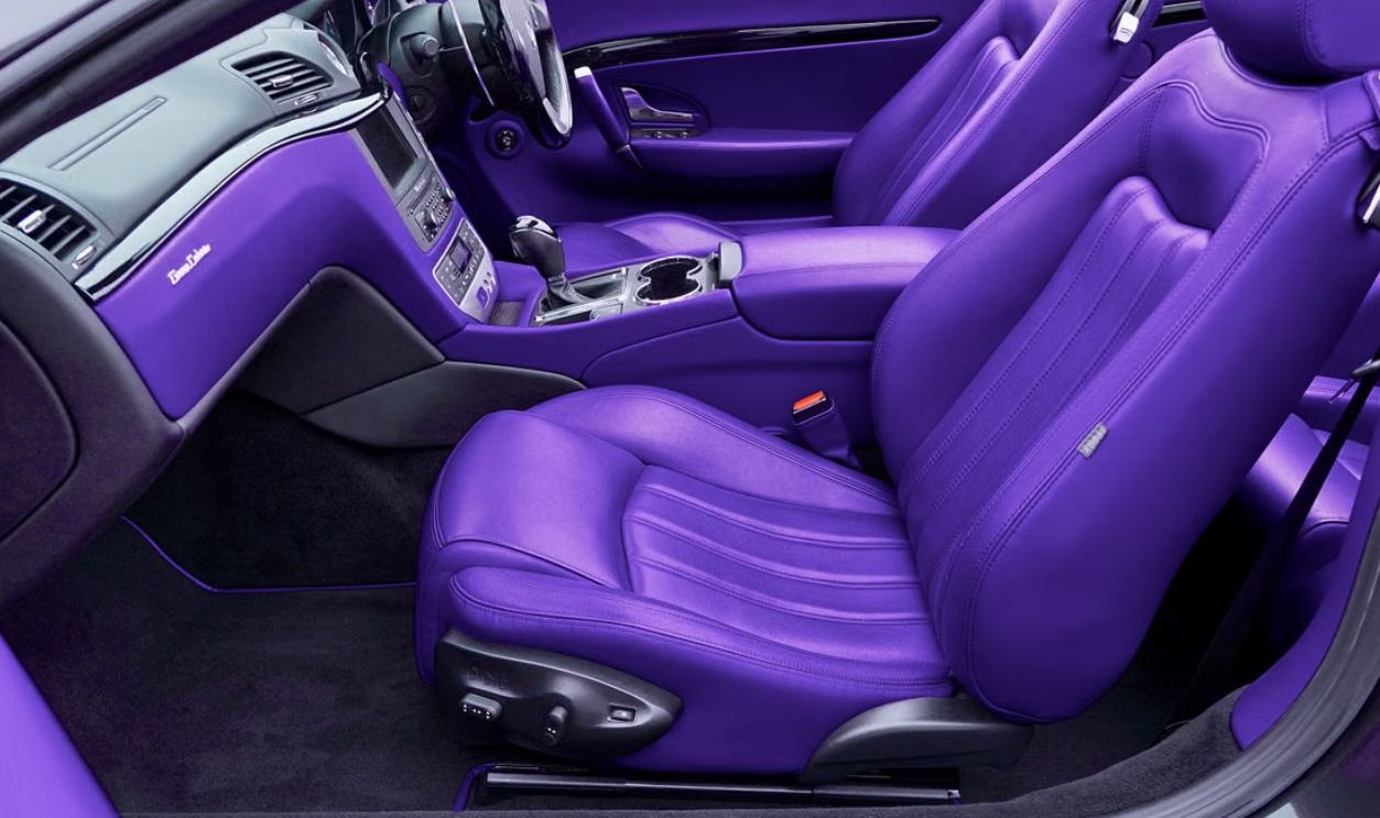 Vibrant violet leather interior of a luxury car, showcasing premium seats and dashboard in detail