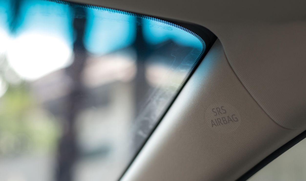 Sign of SRS Airbag, Supplemental Restraint System Airbag, on A-pillar of modern car interior. It helps to prevent driver and passenger from going through windshield, shallow depth of field