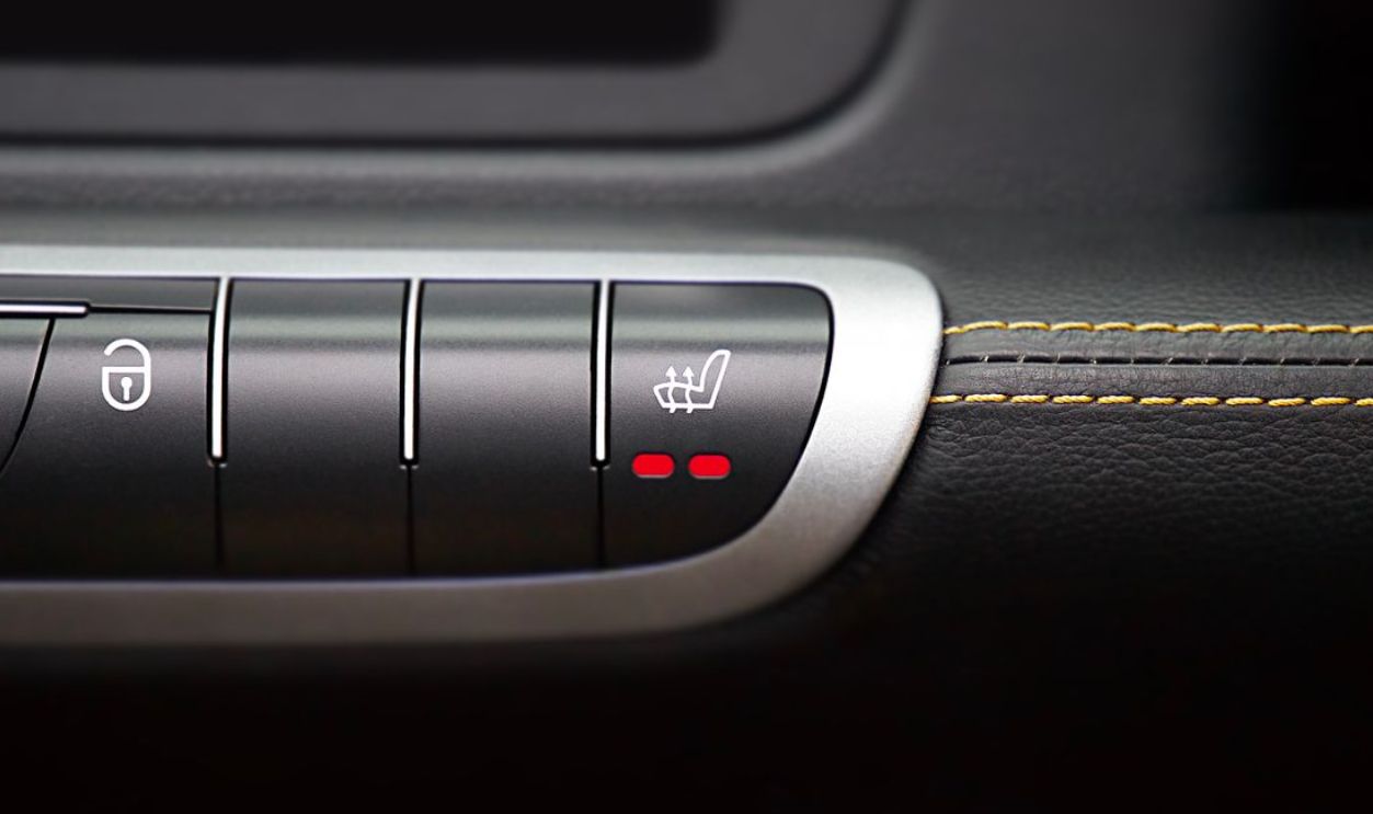 Close-up of modern car interior control panel featuring heated seat and central locking buttons