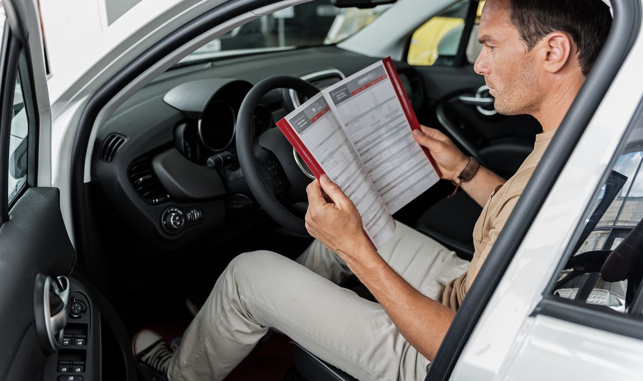 Serious man reading information about car