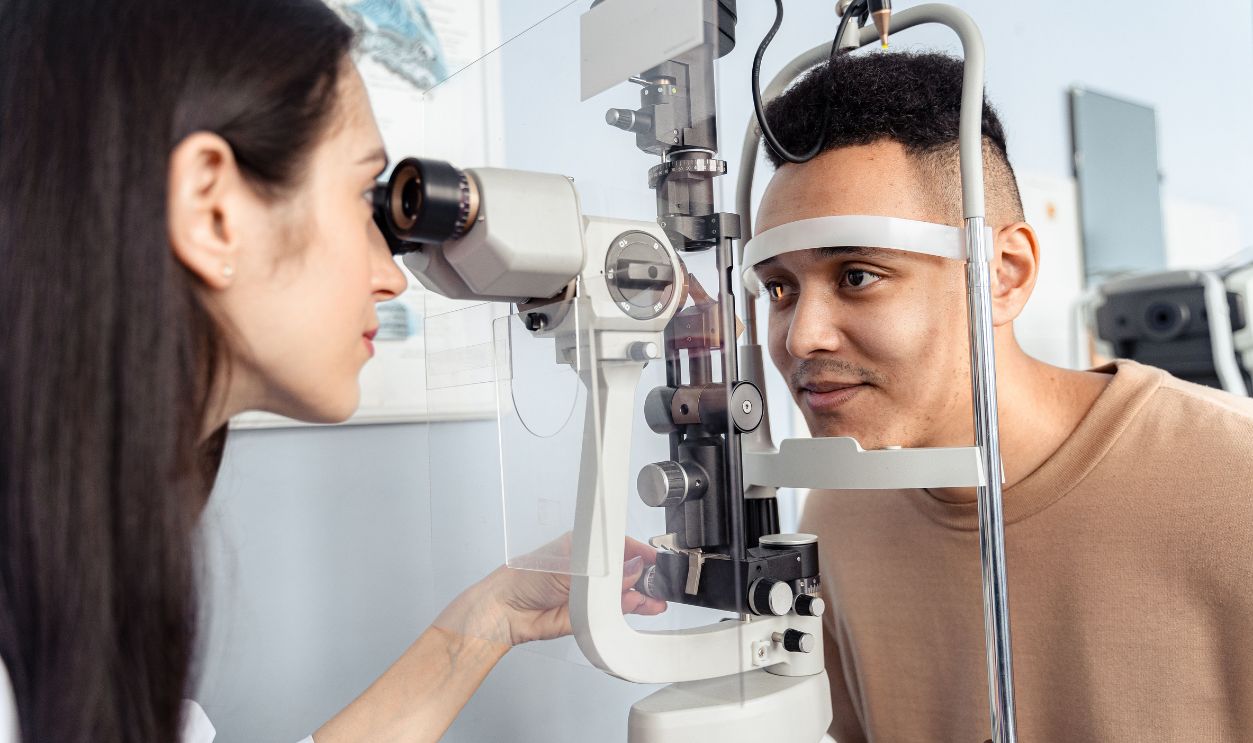 Optometrist examining a patient's eyes with specialized equipment in a clinic