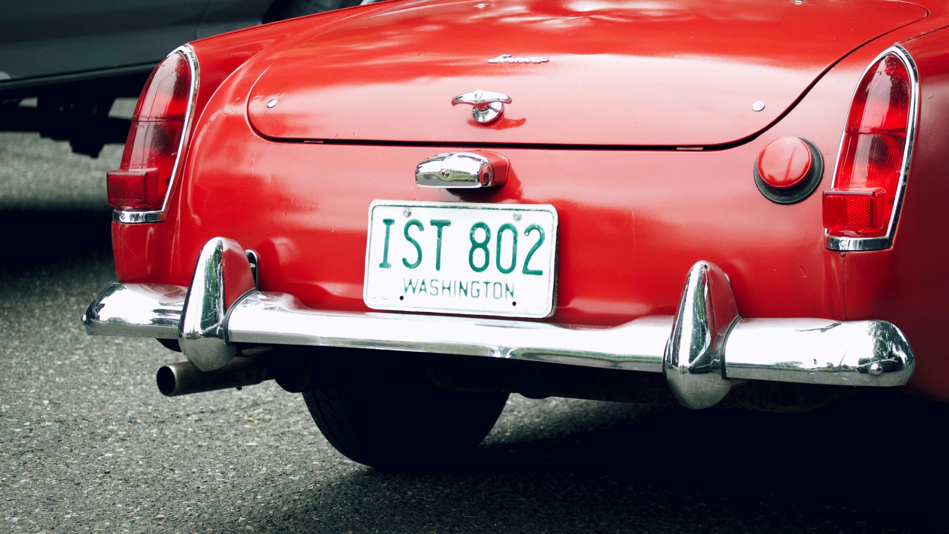 A red classic car's rear view.
