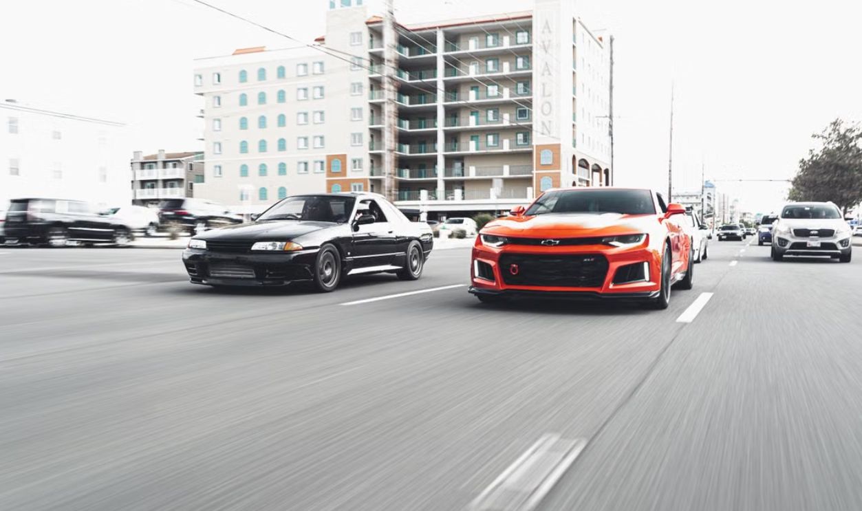 Dynamic shot of two high-performance cars racing on a city street with urban buildings in the background