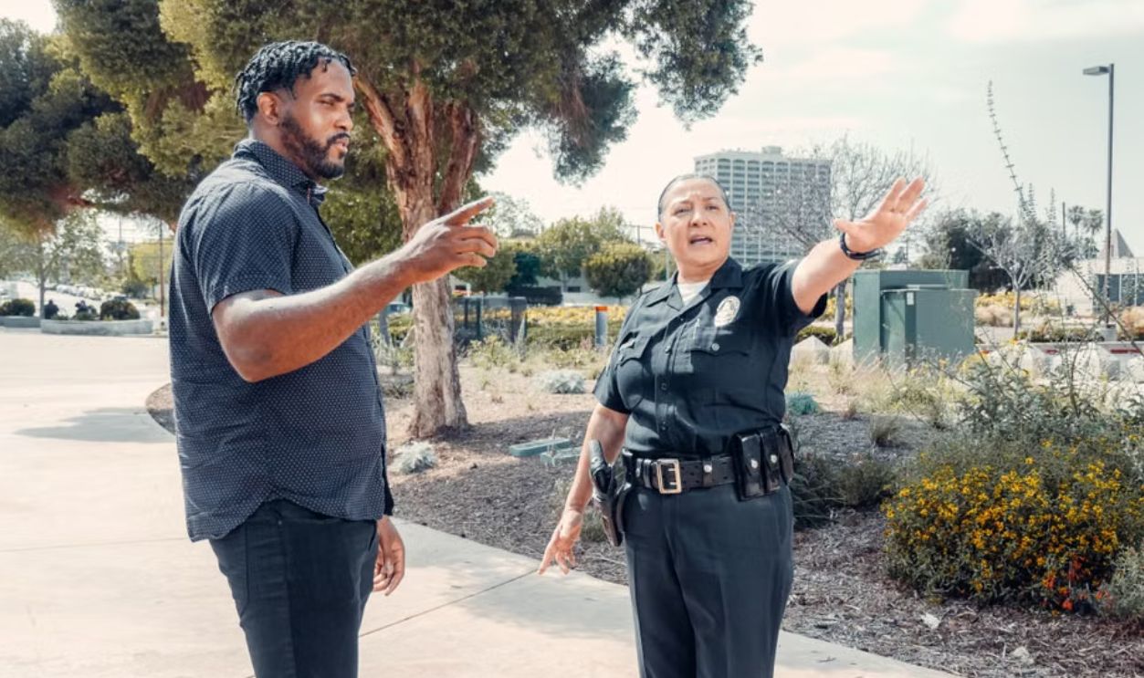 Police officer speaking with a man outdoors, showcasing community engagement