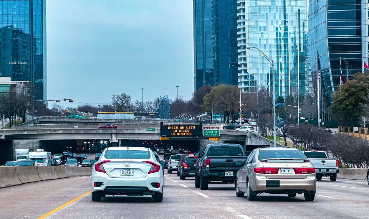 Busy traffic scene on a Dallas highway with skyscrapers in the background