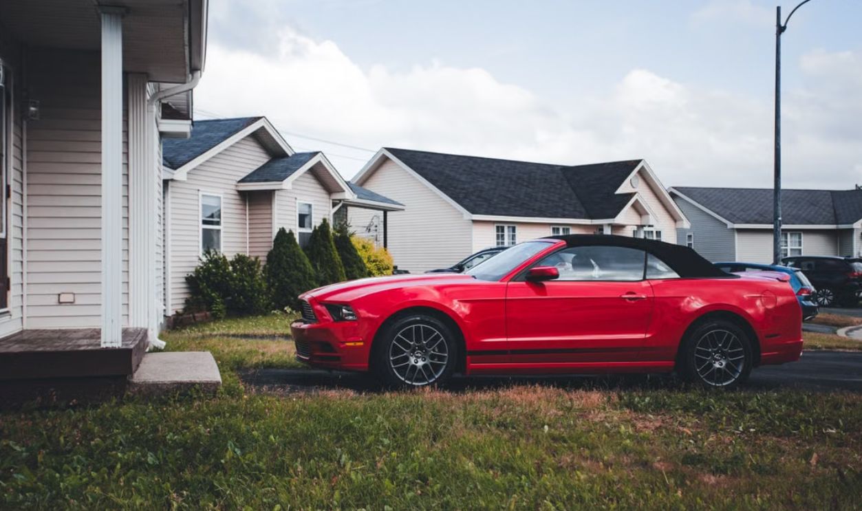 Red convertible parked in a suburban neighborhood driveway, showcasing modern car design