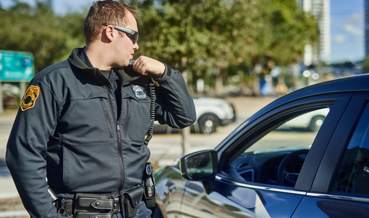 Police, radio and security with a man officer outdoor on patrol while talking to headquarters for a situation report. Law, safety and communication with a policeman on the street for justice