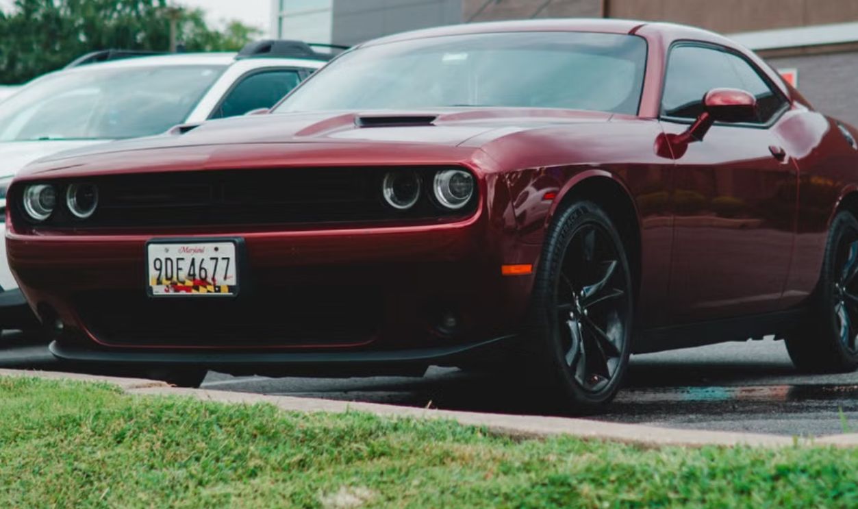 Red Dodge Challenger parked in a McDonald's lot, showcasing its sleek design.