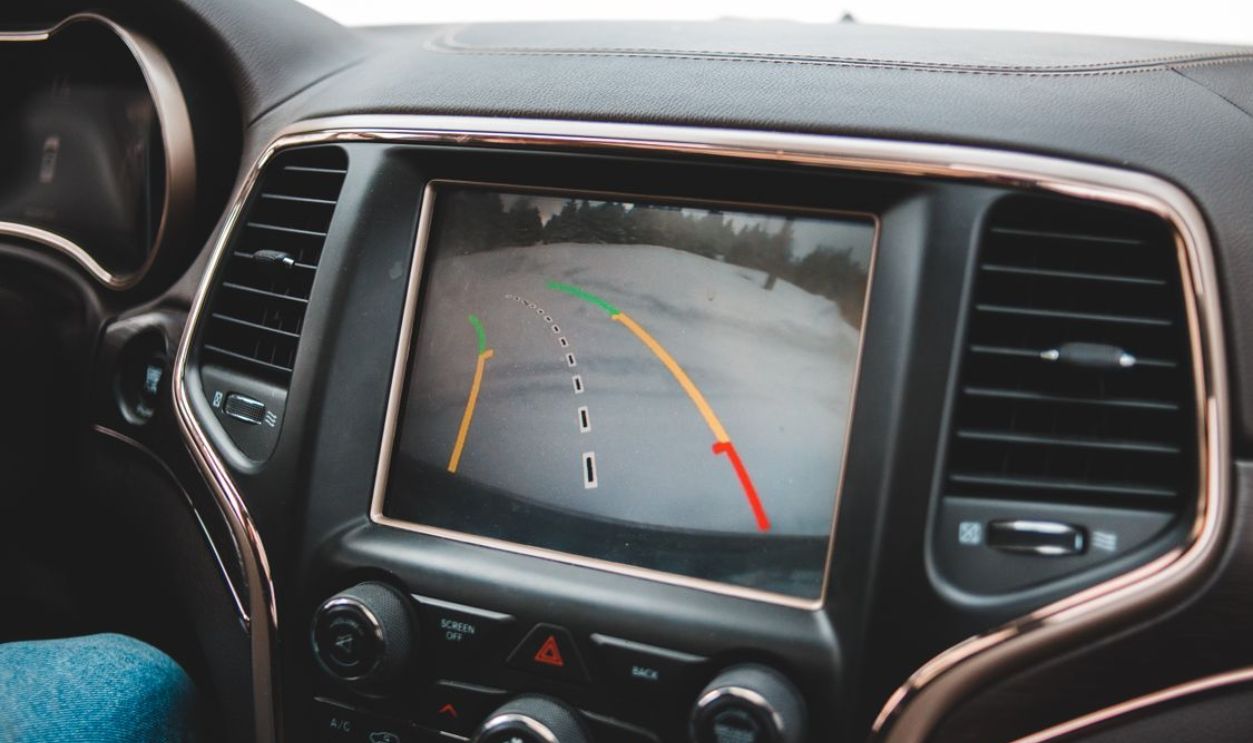 Close-up of a car's dashboard showing a rearview camera display for parking assistance