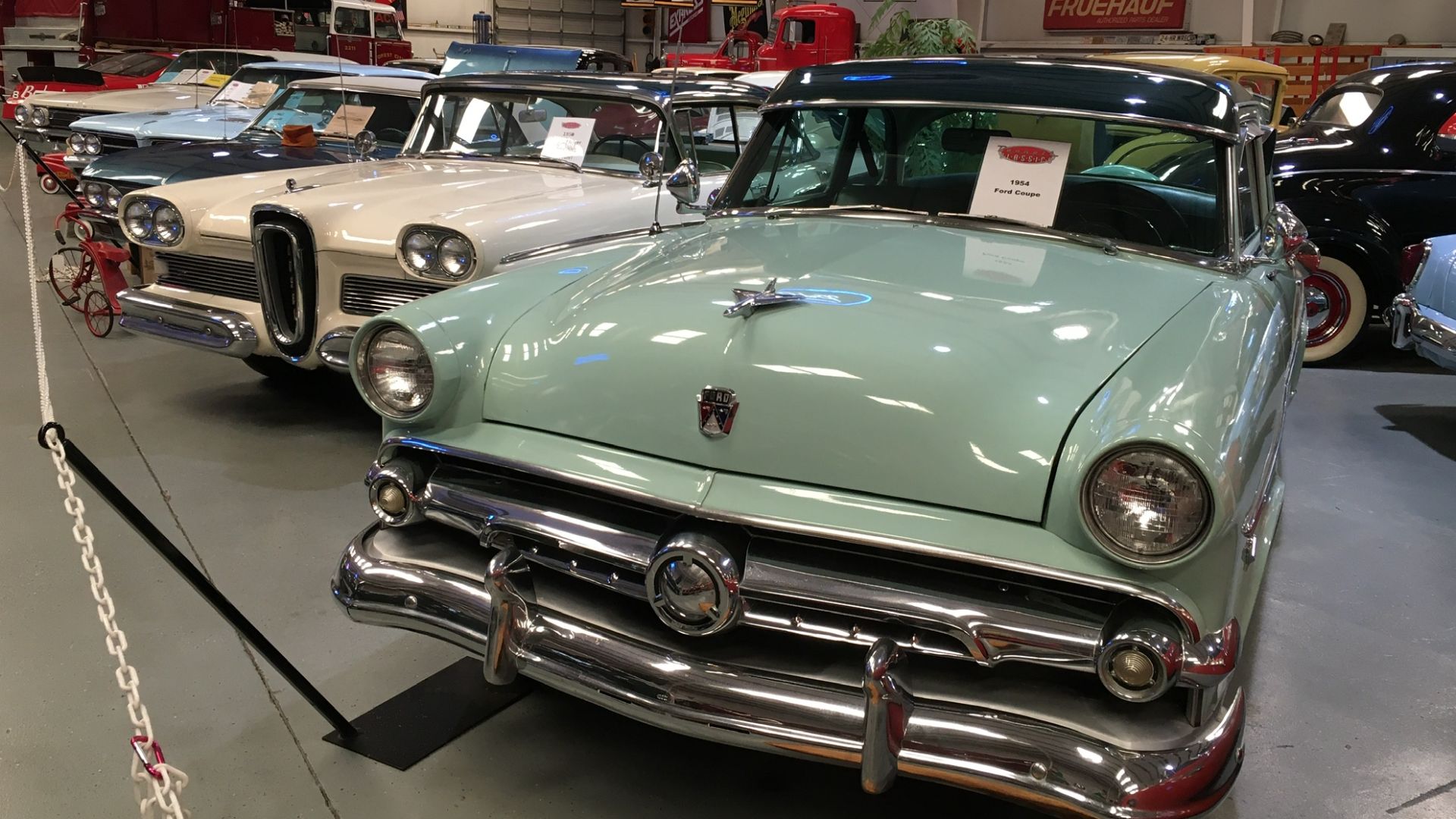 some classic cars in a car museum, including an Edsel Pacer