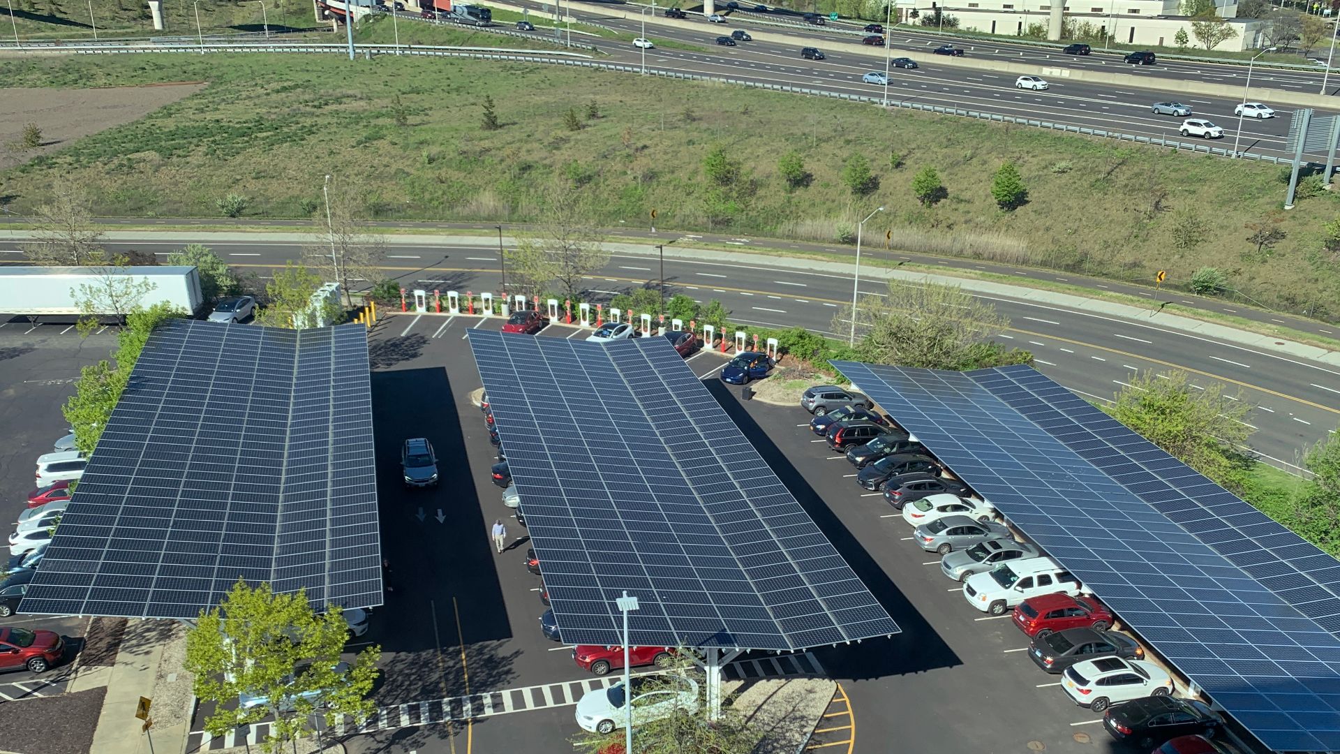 This solar canopy is at the car park of the Hotel Marcel in New Haven, CT. Hotel Marcel is a zero carbon hotel. These panels contribute to achieving zero carbon, partly by exporting energy to the grid. There are EV level 2 chargers underneath the canopy a