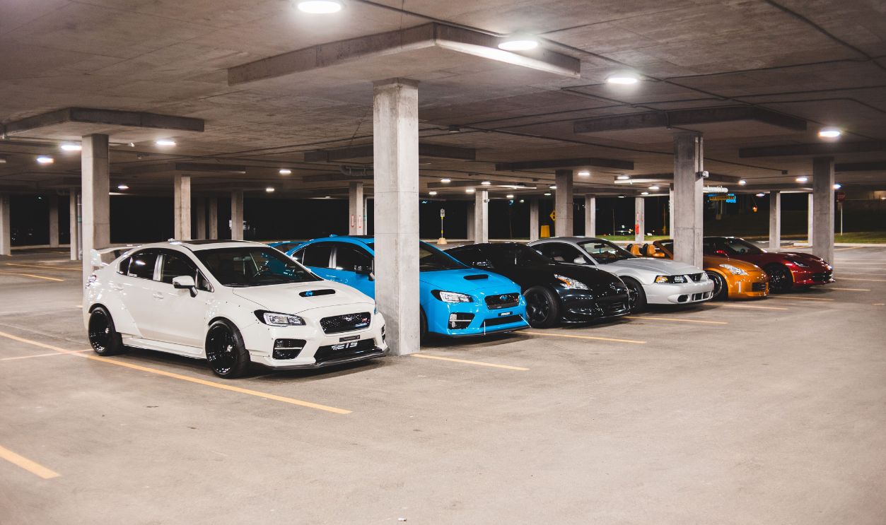 A variety of sports cars parked in a modern urban garage