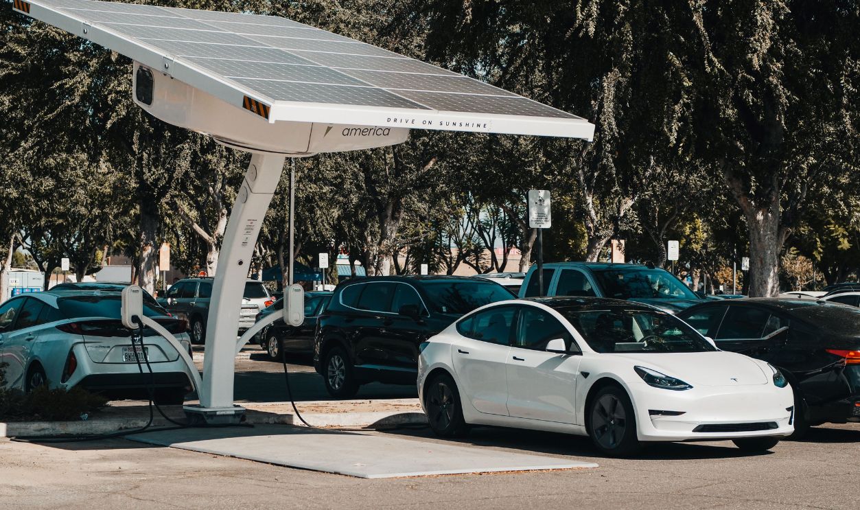Electric car parked at a solar charging station outdoors, highlighting renewable energy