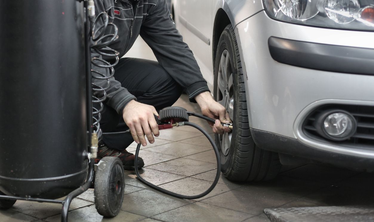 Mechanic inspecting and adjusting tire pressure