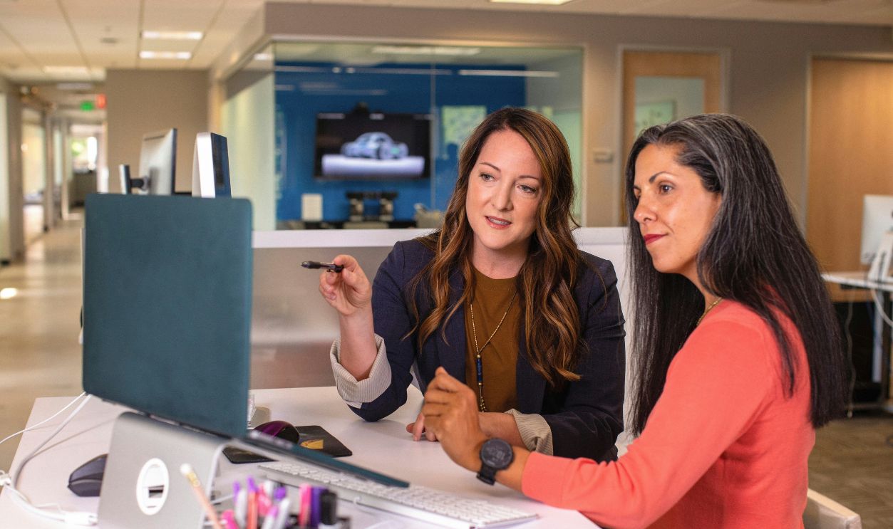 Two business women talking about sales in office 