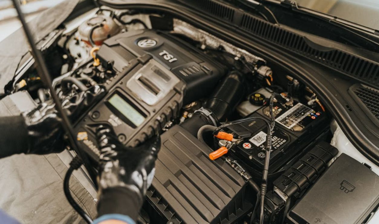Close-up view of a mechanic diagnosing a Volkswagen engine with specialized equipment