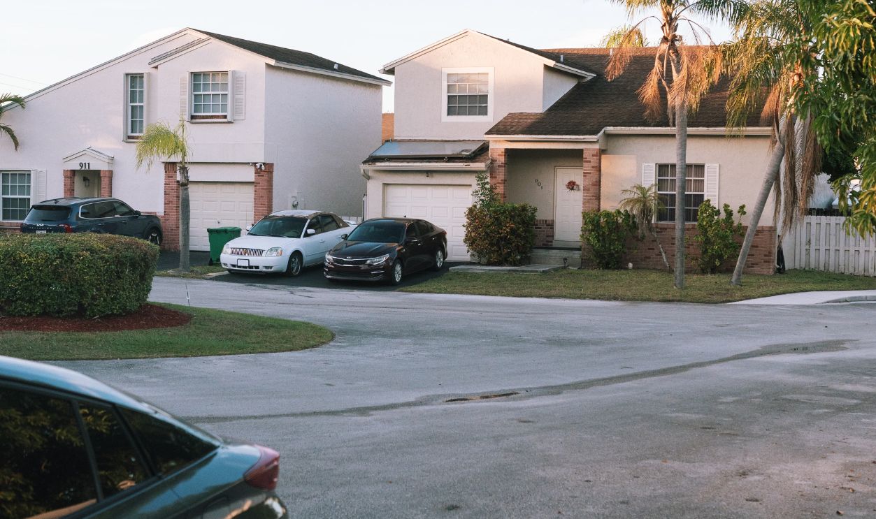 Charming suburban street with modern houses and palm trees at sunset, serene environment