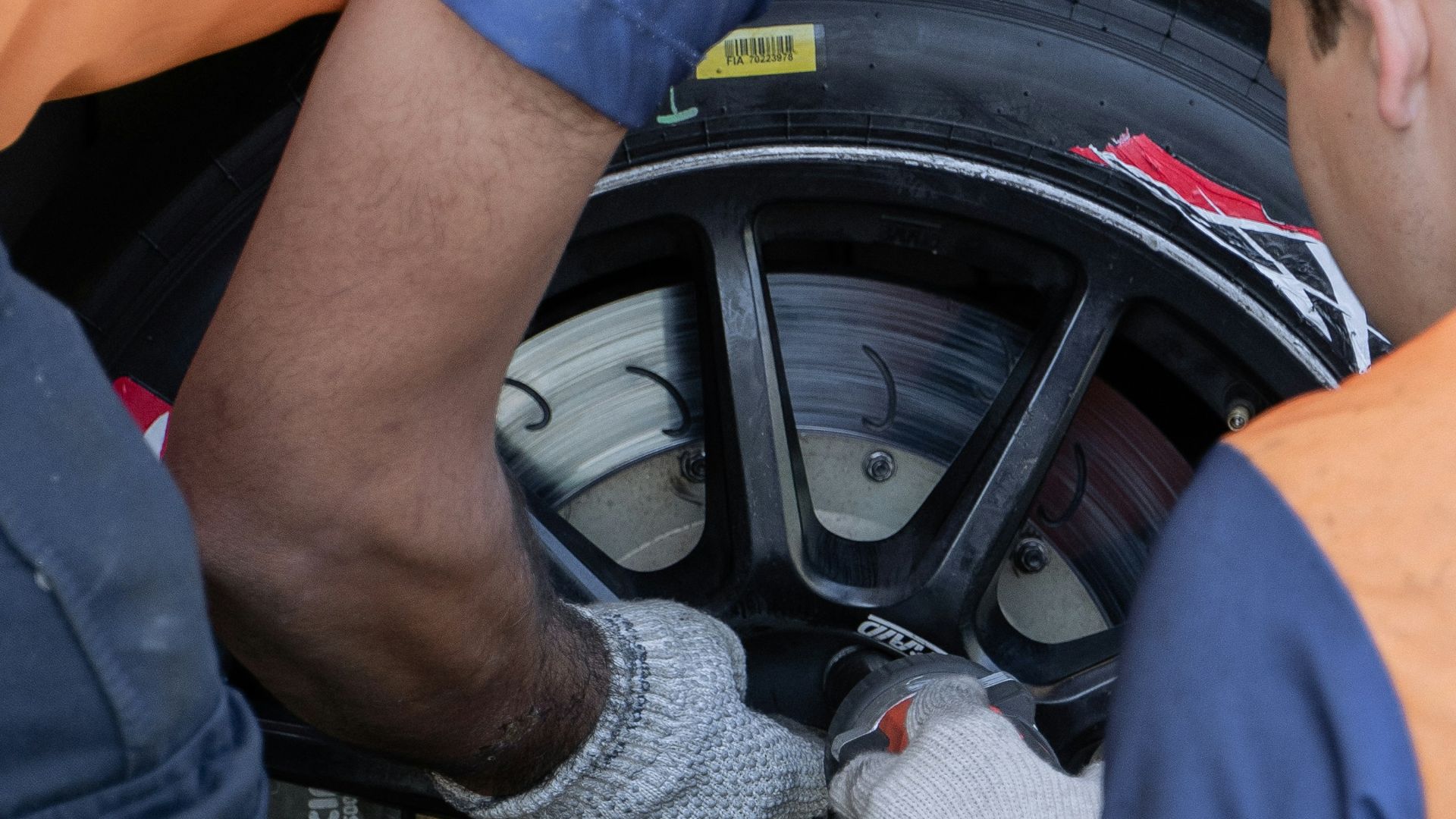 two men working on a tire on a car