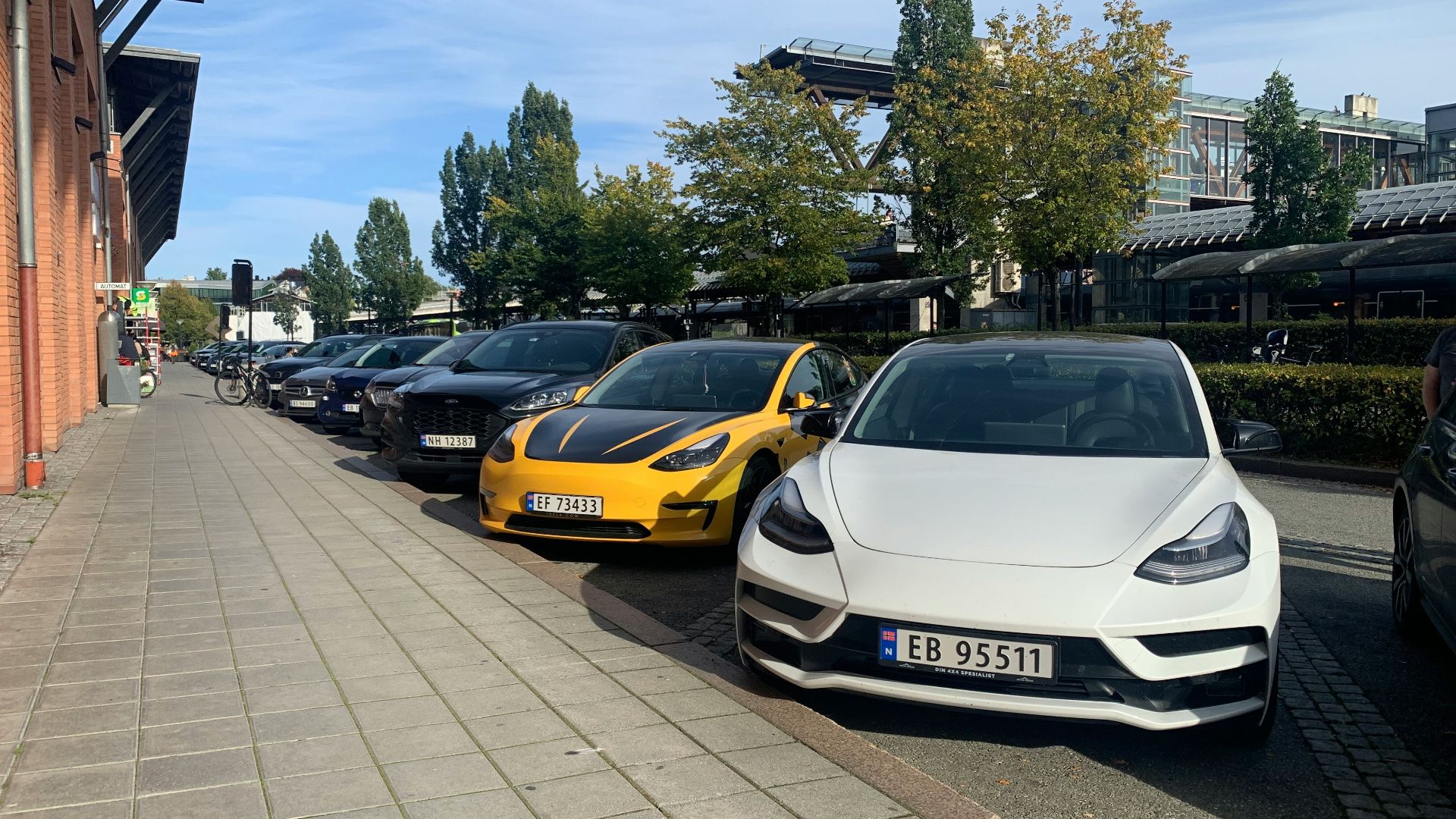 a row of cars parked on the side of a road