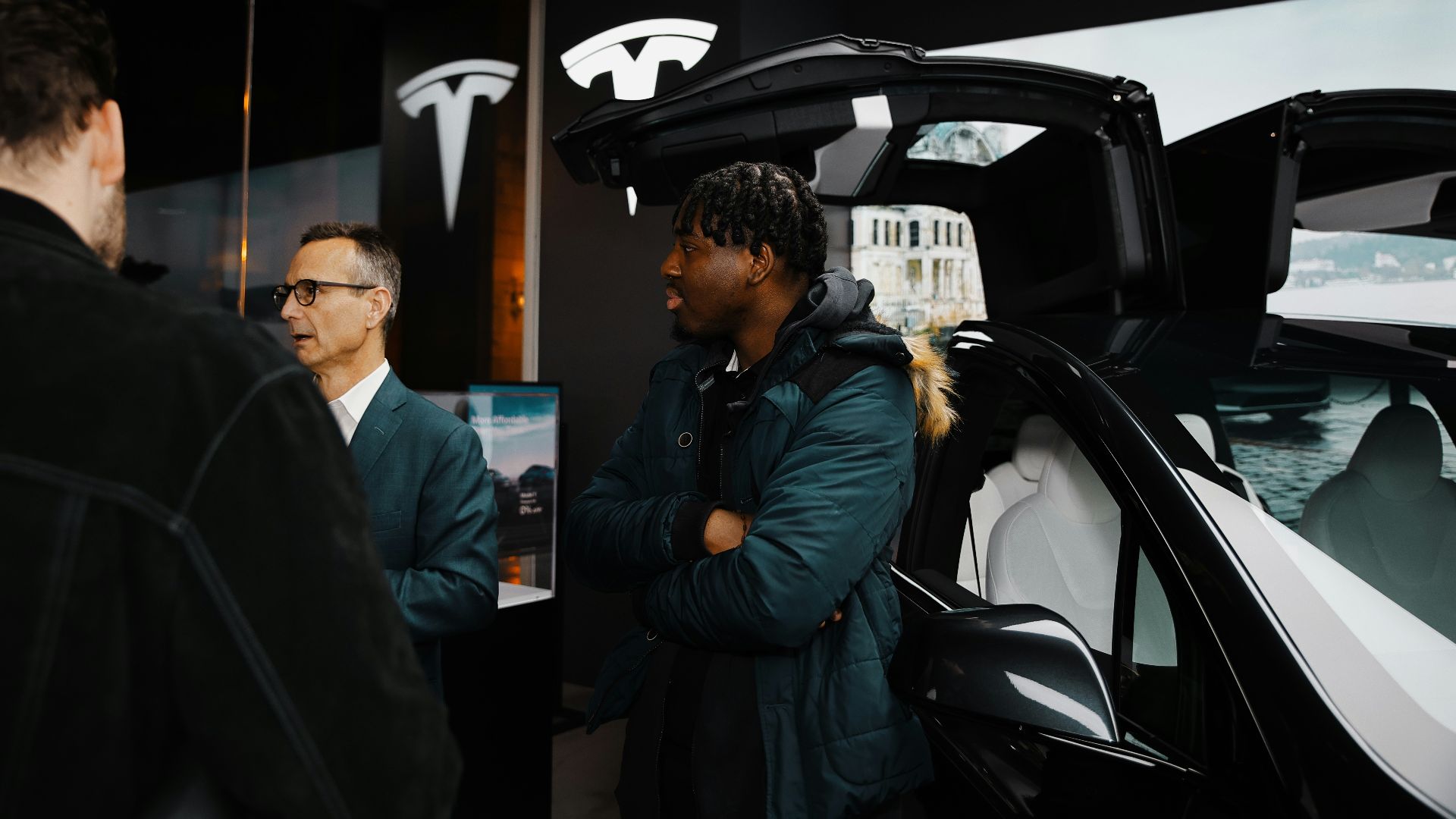A group of people standing around a car