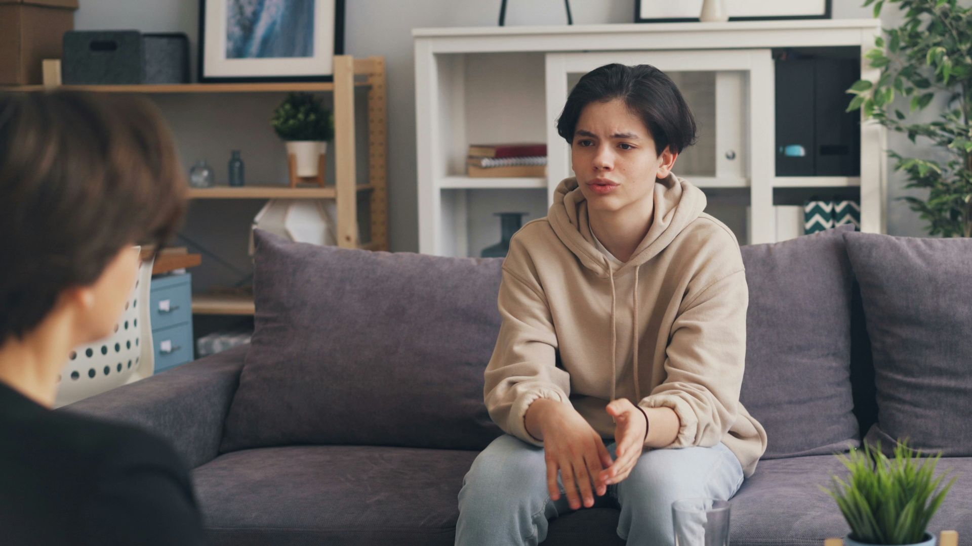 a woman sitting on a couch talking to a man