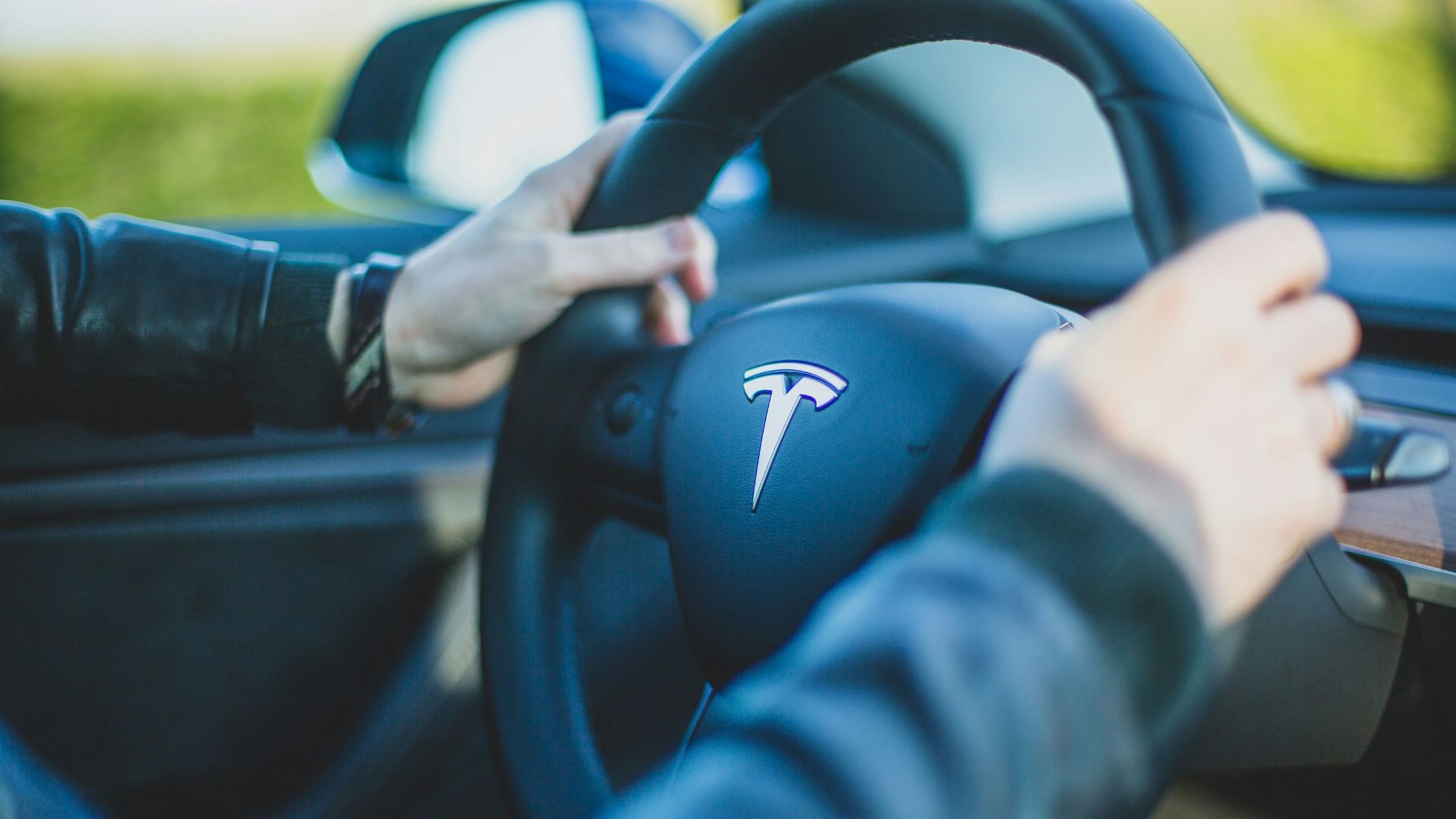 person holding vehicle steering wheel