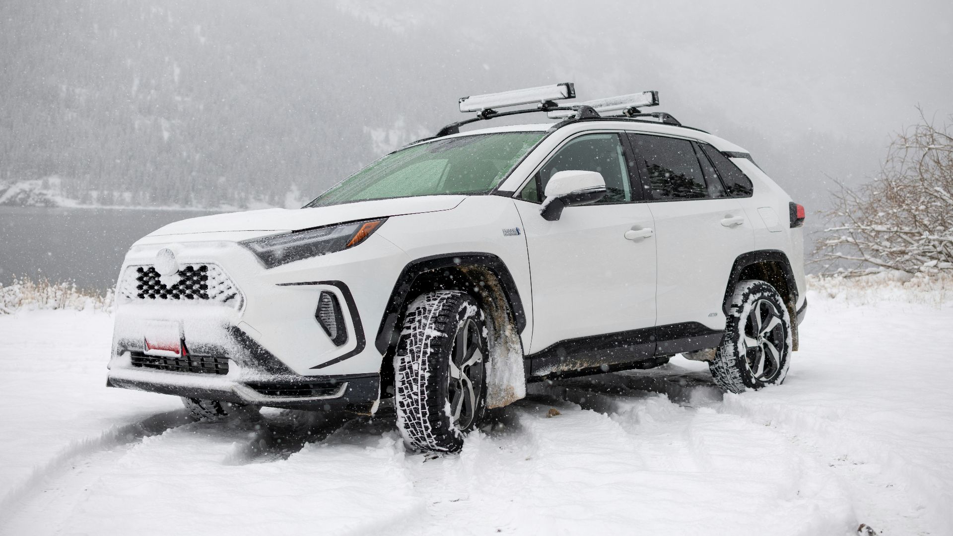 a white suv is parked in the snow