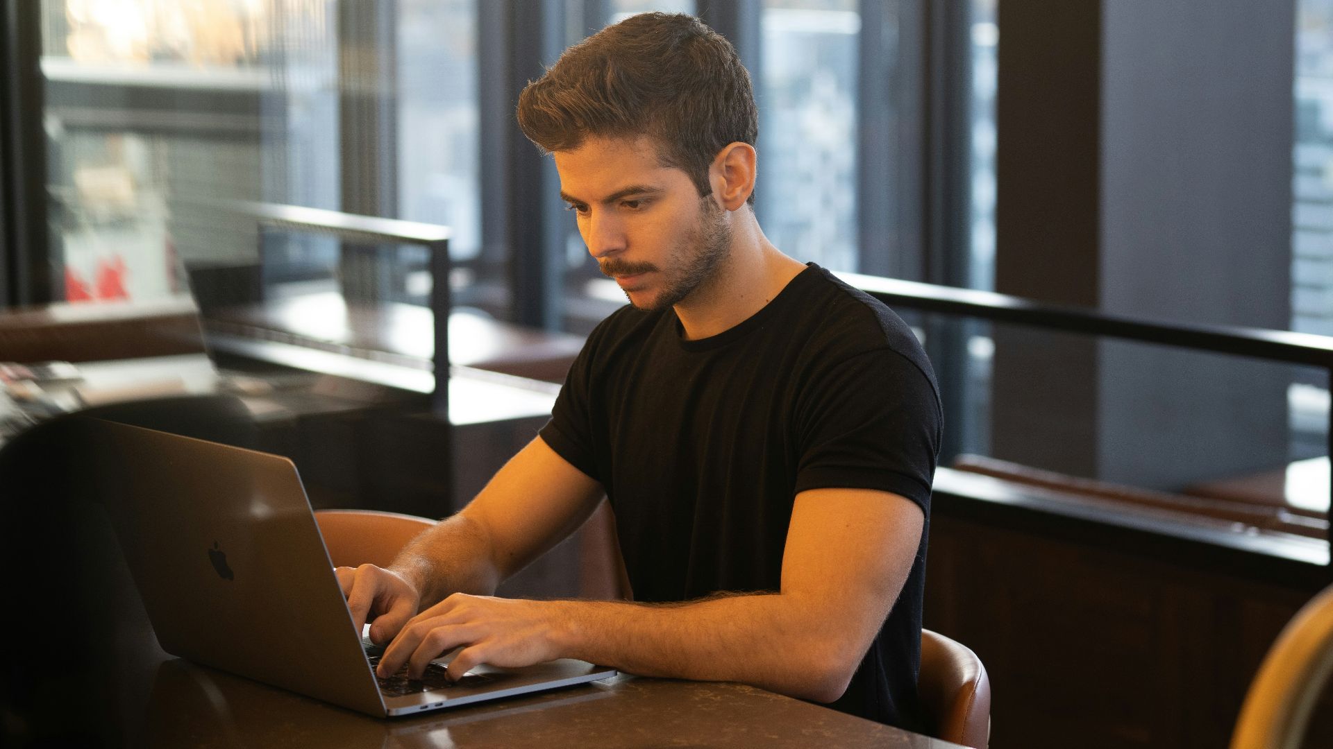 man in black crew neck t-shirt using macbook