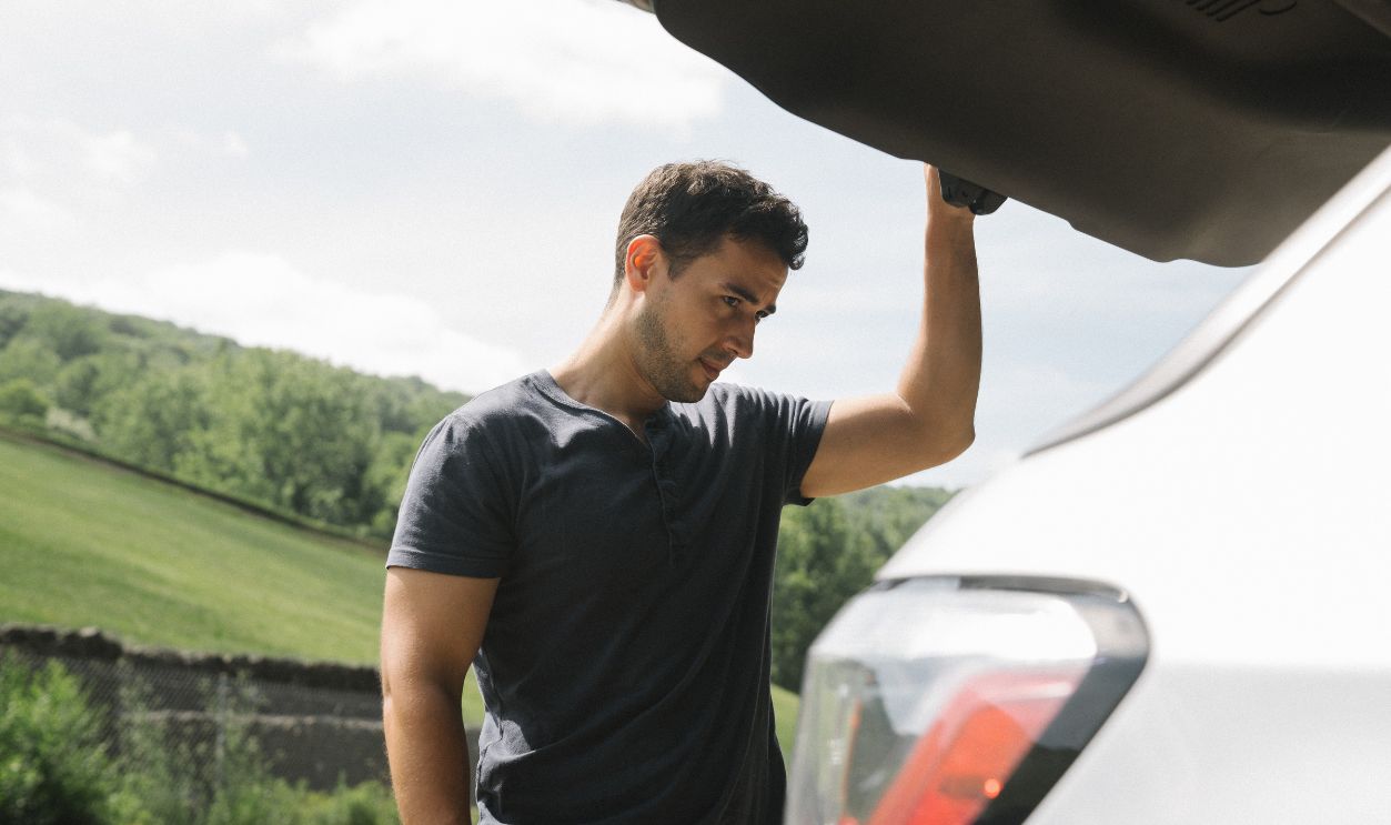 A man examining the open trunk 