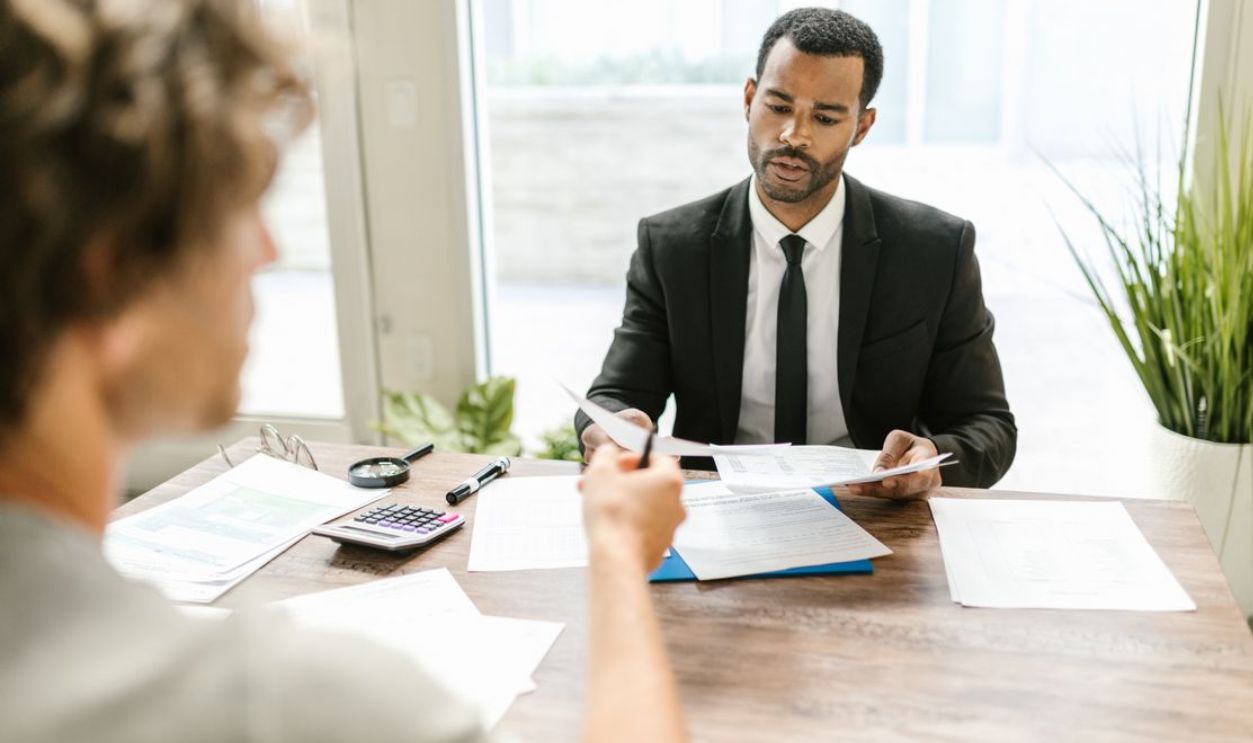Businessman in a suit reviewing documents during a meeting indoors with a colleague