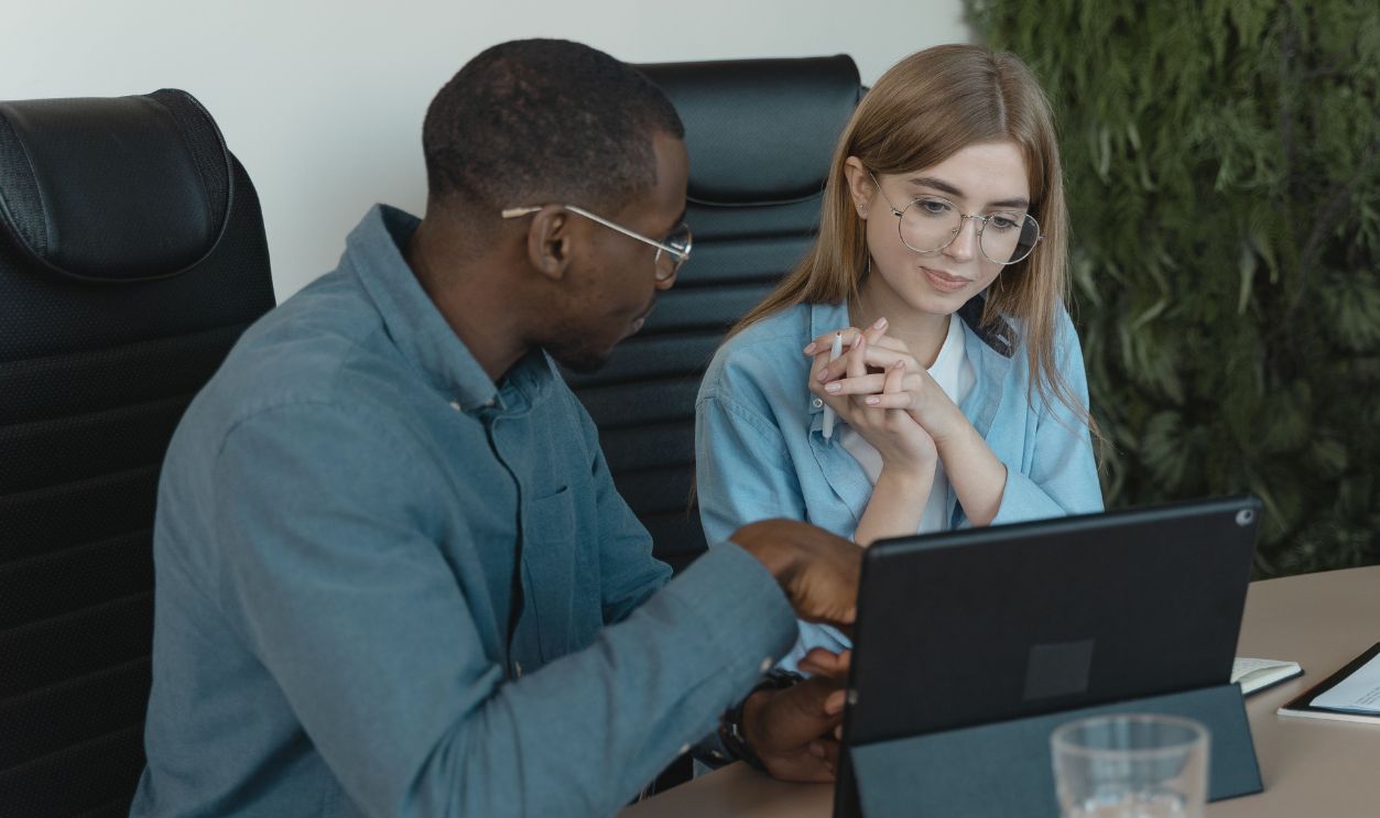 Two professionals engaged in collaborative discussion using a tablet in a contemporary office 