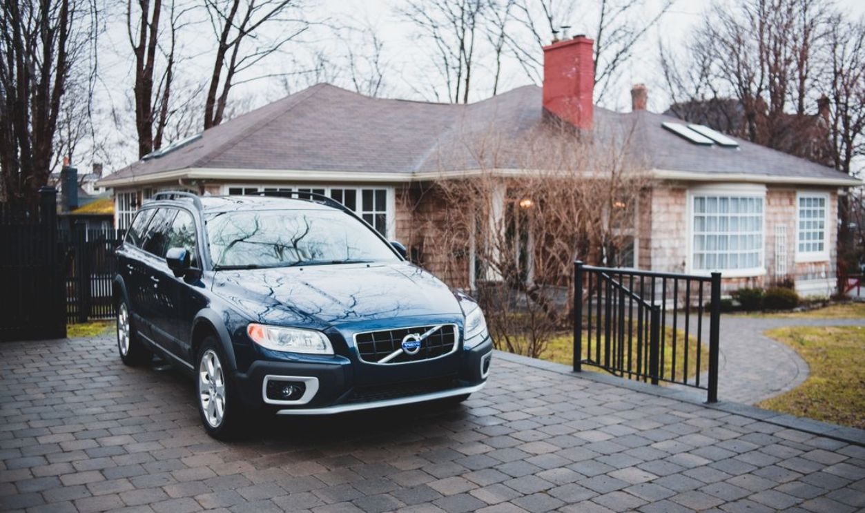 Charming suburban house with a car parked in the driveway on an overcast day