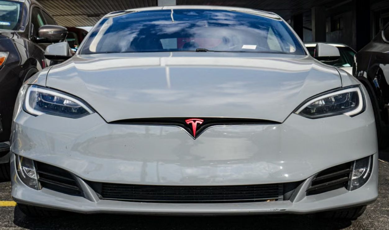 Front view of a Tesla Model S parked in an urban area, highlighting sleek design and modern aesthetics