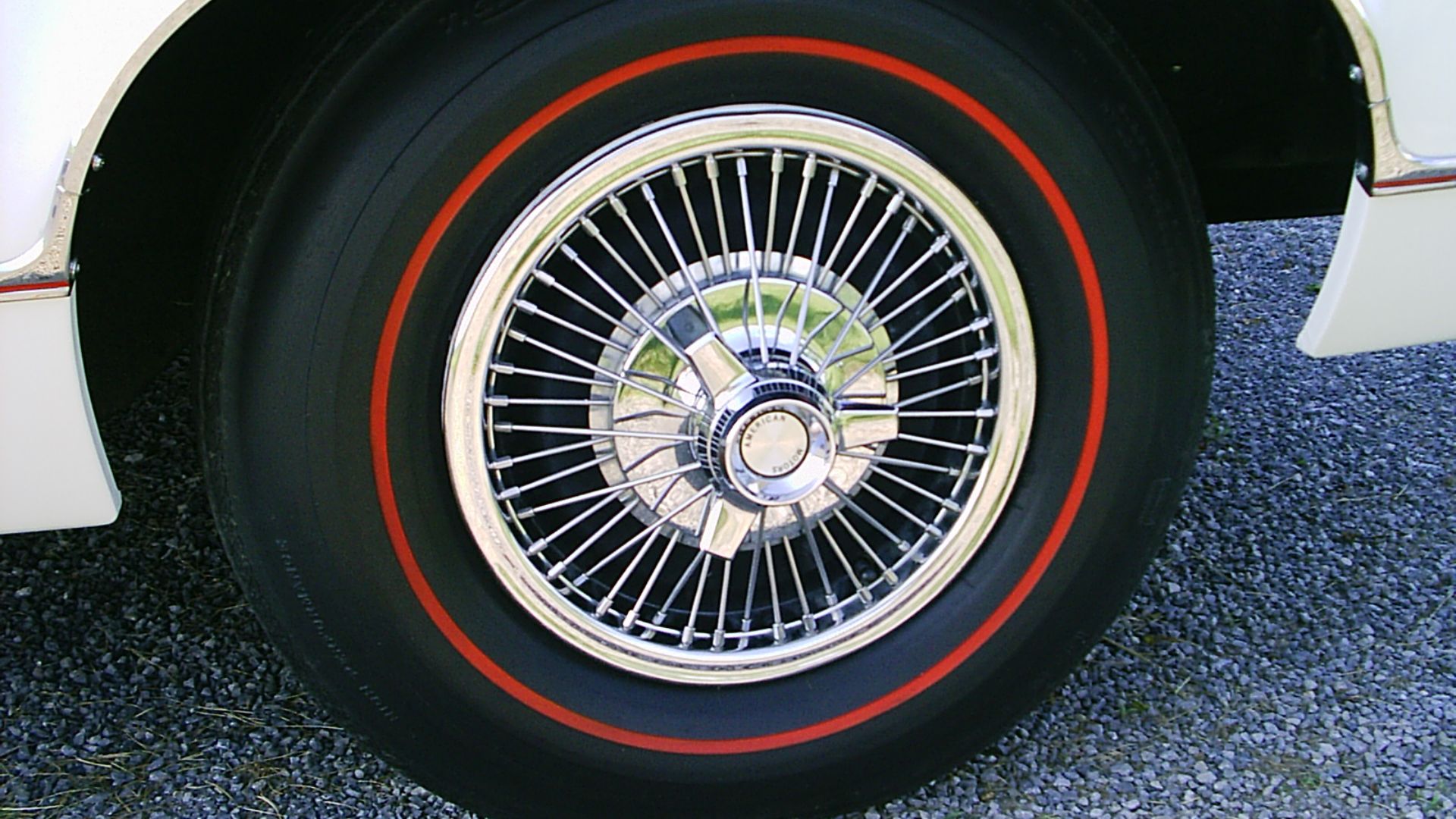 Original factory wire wheel cover on a 1967 AMC Marlin (American Motors Corporation) with vintage US Royal