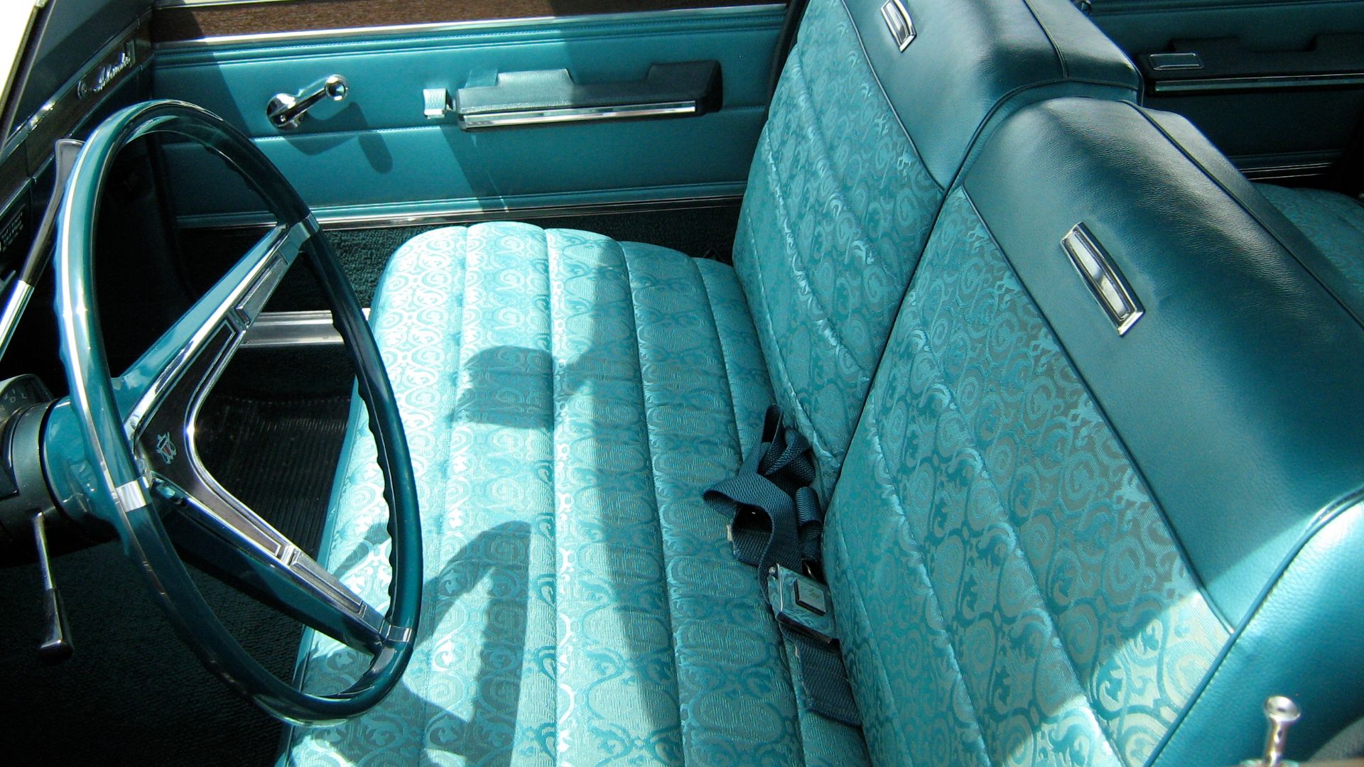 1967 Ambassador 990 four-door sedan by American Motors Corporation (AMC). This car is finished in two-tone aqua paint (Alameda Aqua #P34 primary color and Marina Aqua Metallic #P8 on the roof) with a matching standard interior upholstery and bench seats. 