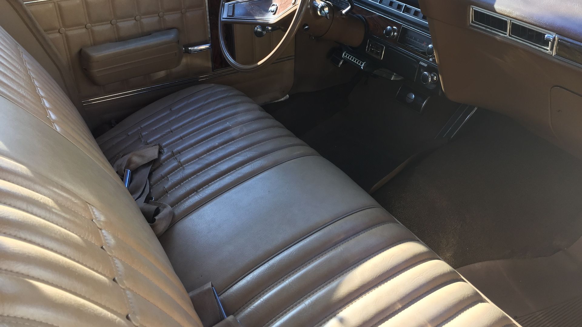 1970 Chevrolet Kingswood Estate. A surviving original factory condition four-door station wagon with three rows of seats, with the rearmost one facing backwards. Finished in beige with woodgrain paneling trim on bodysides and tailgate. This car also has t
