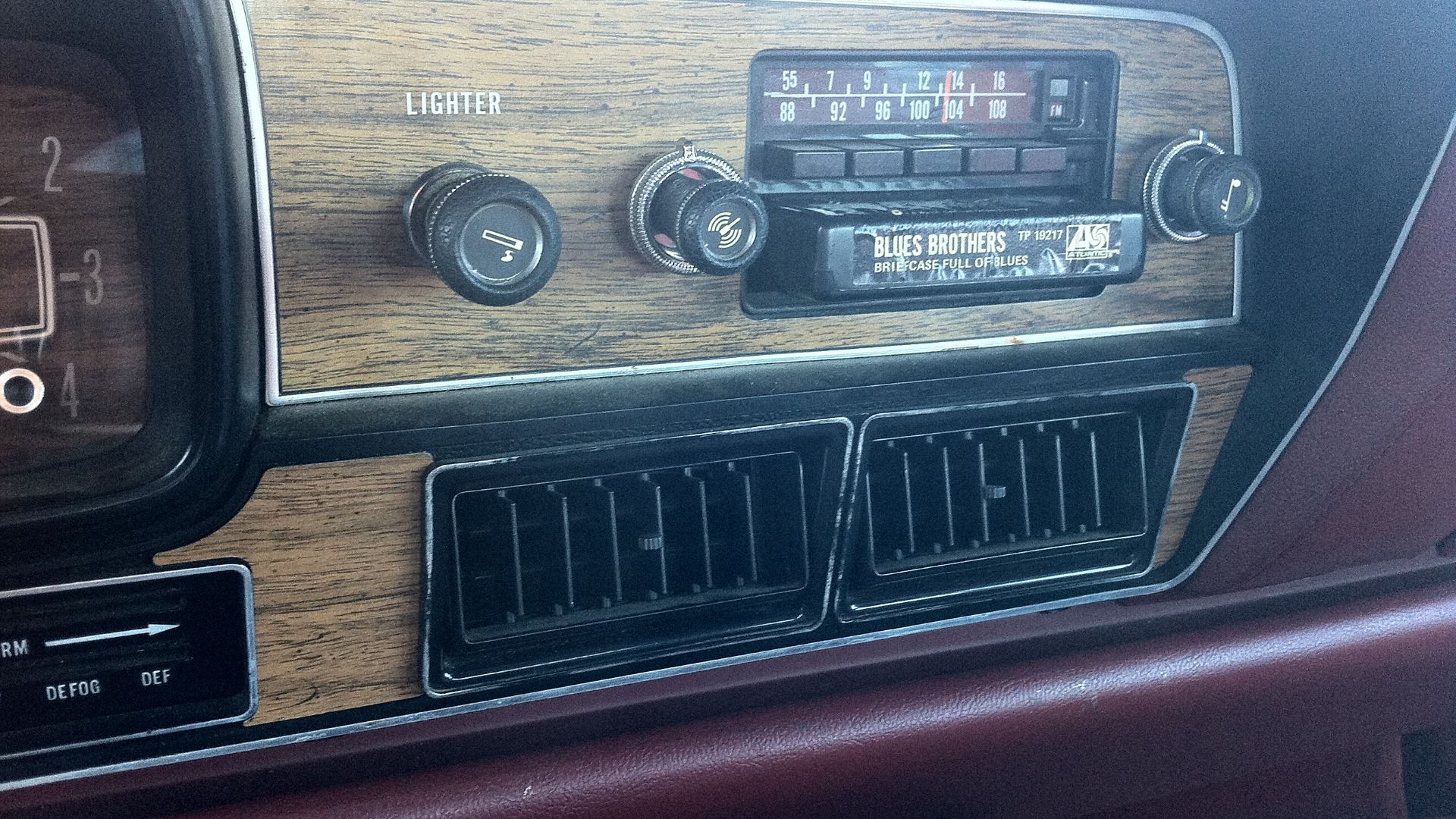 Detail of the factory installed AM/FM/8-track stereo audio unit in the instrument panel of a 1978 AMC Matador four-door sedan (made by American Motors Corporation). Also shown is the a tape cartridge in
