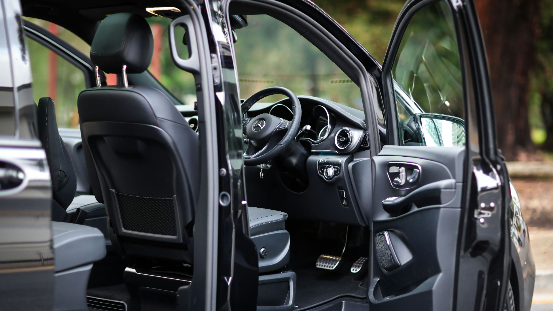 The open door shows a luxury car interior.